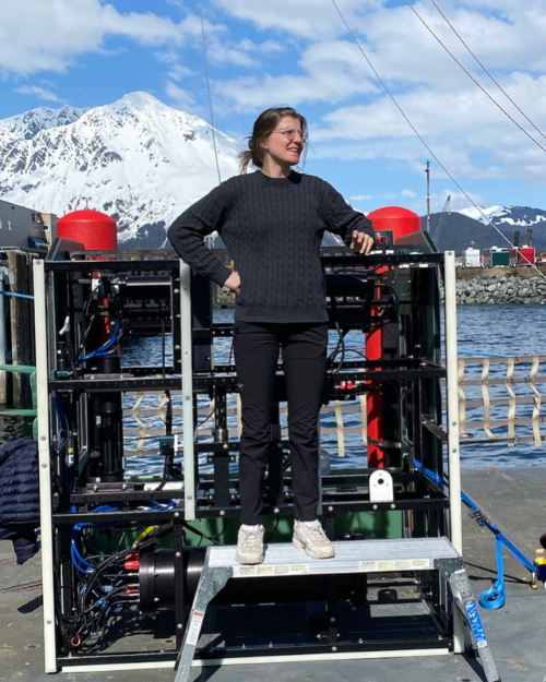 Hannah Kepner standing with an oceanographic imaging system during fieldwork.